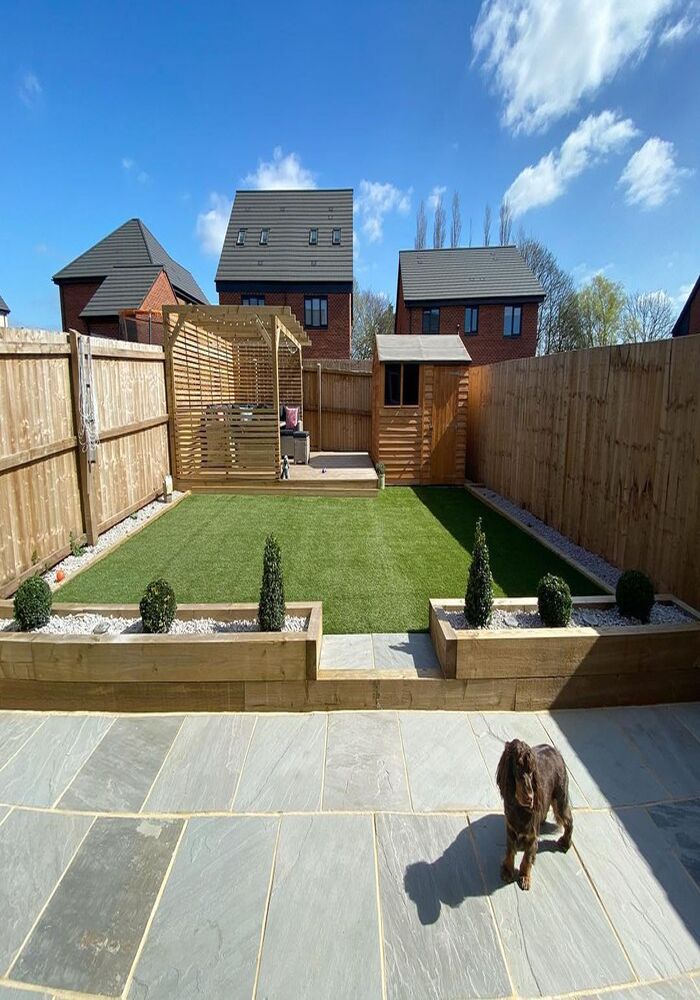 Landscaped garden with sleeper beds, artificial lawn and porcelain patio - All Aspects Construction