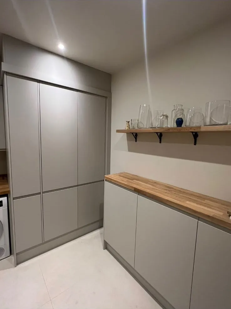 Utility room with full-height grey shaker cupboards, oak worktop and floating shelf